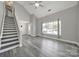 An open living space with gray floors has large windows, a staircase, and a white front door at 2706 Stagbuck Dr, Gastonia, NC 28052