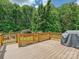 Spacious deck with wooden railing and a grill, backing onto a lush green landscape of trees and foliage at 2927 Dubberly Ct, Matthews, NC 28105