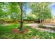 Outdoor space with wooden deck, gravel area, and mature trees at 2953 Enfield Rd, Charlotte, NC 28205