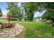 Beautiful backyard featuring a stone patio, lush lawn, mature trees, and access to the water at 307 Lake Head Rd, Norwood, NC 28128