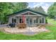 Exterior facade of home showing outdoor stone patio with seating, grill, and nice backyard at 307 Lake Head Rd, Norwood, NC 28128