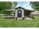 Exterior view of gray outbuilding with a front door and covered patio and outdoor dog enclosure at 307 Lake Head Rd, Norwood, NC 28128