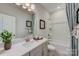 Well-lit bathroom with a single vanity, a bathtub and shower, and decorative curtains at 312 Catawba Ave, Davidson, NC 28036