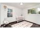 Bright Bedroom featuring a white crib, ABC rug, hardwood floors, and natural light from two windows at 3331 Eastwood Dr, Charlotte, NC 28205