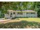 Charming ranch-style home featuring a covered porch, lush green lawn, and mature shade trees at 3331 Eastwood Dr, Charlotte, NC 28205