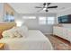 Bright bedroom with a king-sized bed, modern ceiling fan, hardwood floors, and white dresser with a TV at 3809 Topsfield Rd, Charlotte, NC 28211