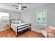 Bright bedroom with a queen sized bed, ceiling fan, hardwood floors, and a window at 3809 Topsfield Rd, Charlotte, NC 28211
