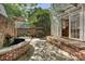 Outdoor patio features brick walls, stone ground, a built-in water fountain and door access to indoor kitchen at 402 W 8Th St, Charlotte, NC 28202