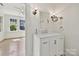 Bright bathroom features a white vanity, marble countertop and antique lighting fixtures at 402 W 8Th St, Charlotte, NC 28202