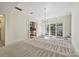 Open dining room with carpet, chandelier, and view into kitchen and backyard at 402 W 8Th St, Charlotte, NC 28202