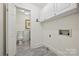 Well-lit laundry room with overhead cabinets, stained glass window, and gray wood-look floors at 402 W 8Th St, Charlotte, NC 28202