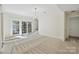 Bright living room with light-colored walls and light-colored carpet, with doors leading to outdoor area at 402 W 8Th St, Charlotte, NC 28202