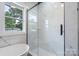 Modern bathroom with a free-standing tub, glass enclosed shower and marble tile at 418 Link St, Fort Mill, SC 29715