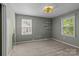 Cozy bedroom with two windows and a custom light fixture and shelving at 4232 Saint Audrey Pl, Charlotte, NC 28269
