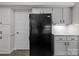 Kitchen area showcasing modern black refrigerator and updated light gray cabinets at 4232 Saint Audrey Pl, Charlotte, NC 28269