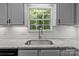 Bright kitchen sink area with updated light gray cabinets, stainless fixtures, and a window with a view at 4232 Saint Audrey Pl, Charlotte, NC 28269