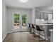 Eat-in kitchen with breakfast bar, gray cabinetry, and backyard views through the french doors at 4232 Saint Audrey Pl, Charlotte, NC 28269