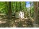 Exterior shot of a storage shed sitting in a lush backyard wooded area at 4232 Saint Audrey Pl, Charlotte, NC 28269