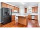 Well-lit kitchen with wood cabinets, an island, stainless steel appliances, and hardwood floors at 4504 Sages Ave, Indian Trail, NC 28079