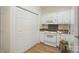 Kitchen area featuring a white oven and microwave, laminate flooring and white cabinets at 608 Camrose Ne Cir, Concord, NC 28025