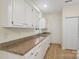 Cozy kitchen featuring white cabinets, laminated countertops, and neutral walls at 608 Camrose Ne Cir, Concord, NC 28025