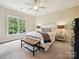 Bedroom with large window, white bed, and overhead fan at 6128 Fletcher Cir, Charlotte, NC 28226