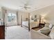 Spacious bedroom with four-poster bed, sitting area, ceiling fan, and large window for natural light at 6128 Fletcher Cir, Charlotte, NC 28226