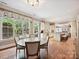 Sunlit dining area with hardwood floors, garden views, and charming window treatments at 6128 Fletcher Cir, Charlotte, NC 28226