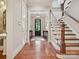 Entryway featuring hardwood floors, staircase with white railing, and black trimmed entry door at 6128 Fletcher Cir, Charlotte, NC 28226