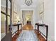 Elegant foyer with hardwood floors, rug, decorative tables, and artwork at 6128 Fletcher Cir, Charlotte, NC 28226
