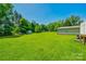 A lush green backyard featuring mature trees, an outbuilding and a garden at 752 Chipmeadow Ln, York, SC 29745