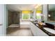 Primary bathroom featuring a glass shower, double vanity, and soaking tub with a large window at 107 Asmodean Ln, Troutman, NC 28166