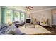 Spacious living room has a fireplace, ceiling fan, and lots of natural light from large windows at 107 Asmodean Ln, Troutman, NC 28166