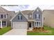 Charming two-story home features a two-car garage, manicured lawn, and inviting entrance at 109 Asmodean Ln, Troutman, NC 28166