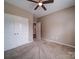Carpeted bedroom featuring a ceiling fan, an open doorway, and a double door closet at 120 Autumn Mist Rd, Statesville, NC 28677
