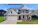 Charming two-story home featuring stone accents, a welcoming porch, and a two-car garage at 125 Asmodean Ln, Troutman, NC 28166