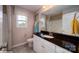 Well-lit bathroom with a black granite countertop, white cabinets, a window, and neutral tiling at 127 Asmodean Ln, Troutman, NC 28166
