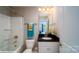 Cozy bathroom featuring a tub-shower combo, neutral tile, and a vanity with granite counters at 127 Asmodean Ln, Troutman, NC 28166