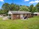 Backyard with a brick house, a patio, and mature trees at 128 Wandering Ln, Bessemer City, NC 28016