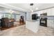 Open kitchen with white cabinets, granite countertops, a center island, and hardwood floors leading to the living room at 128 Wandering Ln, Bessemer City, NC 28016