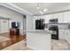 Open kitchen with white cabinets, granite countertops, a center island, and hardwood floors leading to living room at 128 Wandering Ln, Bessemer City, NC 28016