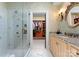 Spacious bathroom featuring a glass-enclosed shower, granite vanity, and a view of the walk-in closet at 13837 Grand Palisades Pkwy, Charlotte, NC 28278