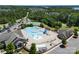 Aerial shot of a community pool area with a water slide, tennis court, and clubhouse at 13837 Grand Palisades Pkwy, Charlotte, NC 28278