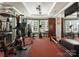 This home has a well-equipped exercise room featuring a variety of equipment and large windows at 13837 Grand Palisades Pkwy, Charlotte, NC 28278