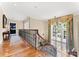 Elegant hallway with hardwood floors, iron railing, and a large window with decorative drapes at 13837 Grand Palisades Pkwy, Charlotte, NC 28278