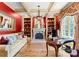 Sophisticated living room with red accent walls, coffered ceiling, and built-in shelving at 13837 Grand Palisades Pkwy, Charlotte, NC 28278