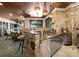 Fully equipped outdoor kitchen boasting stone accents, stainless steel appliances, and a cozy bar area at 13837 Grand Palisades Pkwy, Charlotte, NC 28278
