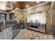Gourmet outdoor kitchen with stainless steel grill, stone wall, sink, and granite countertops at 13837 Grand Palisades Pkwy, Charlotte, NC 28278