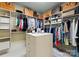Large walk-in closet with custom shelving, an island for storage and designer bags displayed at 13837 Grand Palisades Pkwy, Charlotte, NC 28278