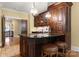 This home features a wet bar with granite countertops, dark wood cabinets and bar stool seating at 13837 Grand Palisades Pkwy, Charlotte, NC 28278